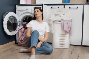 Aprendendo a evitar o problema do desbotamento de roupas coloridas! 4 woman looking tired after doing laundry